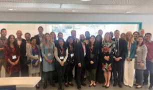 A large group of diverse adults pose for the camera