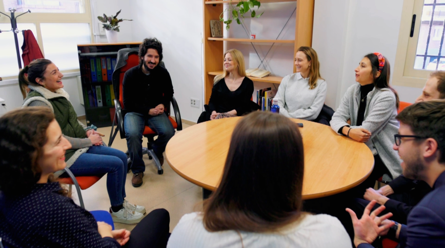Several young men and women sit around a table in discussion